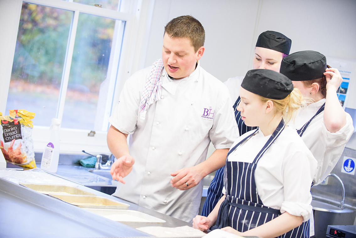 Chef explaining something to other cooks